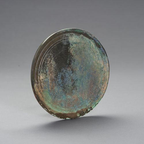 A LARGE BRONZE MIRROR 大型青铜镜
中国，汉代（公元前202年-公元220年）。圆形，设计流畅简洁。

状况。表面有磨损，有丰富的孔雀石绿、&hellip;