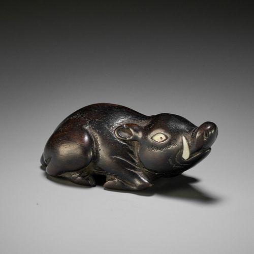 A LARGE AND OLD DARK WOOD NETSUKE OF A RECUMBENT BOAR A LARGE AND OLD DARK WOOD &hellip;