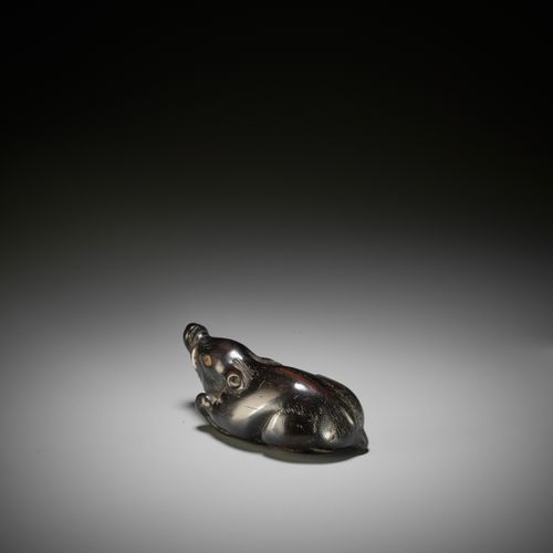 A LARGE AND OLD DARK WOOD NETSUKE OF A RECUMBENT BOAR A LARGE AND OLD DARK WOOD &hellip;