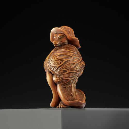 A TANBA SCHOOL WOOD NETSUKE OF A TANUKI WRAPPED IN LOTUS LEAVES 
箪食堂木制网签-荷叶缠身的阿狸&hellip;