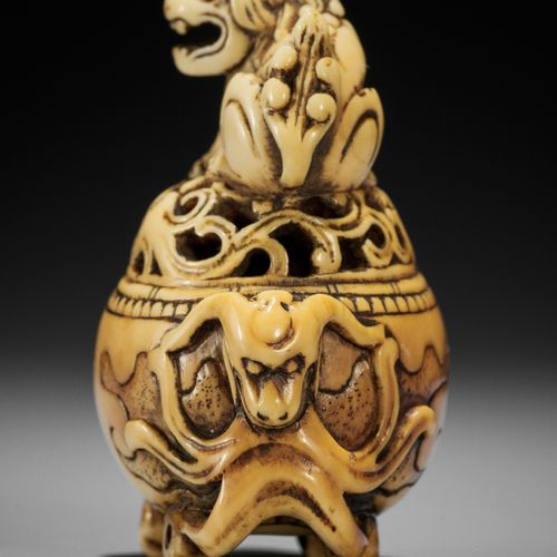 A RARE IVORY NETSUKE OF A KORO (INCENSE BURNER) WITH SHISHI 一件罕见的带石狮的香炉网罩
无签名
 日&hellip;