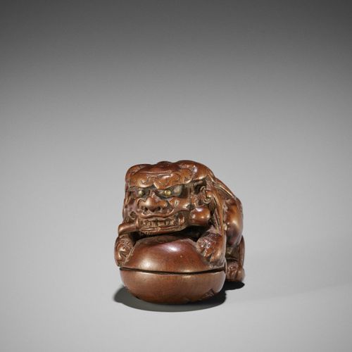 AN EARLY WOOD NETSUKE OF A SHISHI ON A MOKUGYO AN EARLY WOOD NETSUKE OF A SHISHI&hellip;