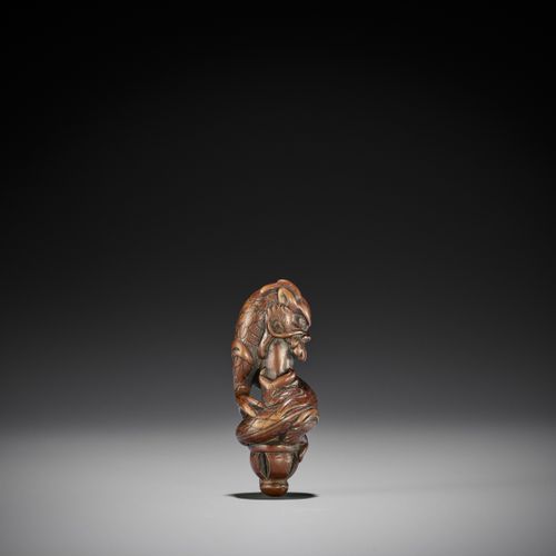 A RARE WOOD NETSUKE OF A DRAGON ON A KEN 罕见的木制龙纹网书
无署名
 日本，18世纪，江户时代（1615-1868）
&hellip;