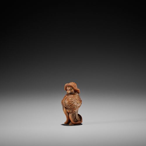 A TANBA SCHOOL WOOD NETSUKE OF A TANUKI WRAPPED IN LOTUS LEAVES 
EIN HOLZ-NETSUK&hellip;