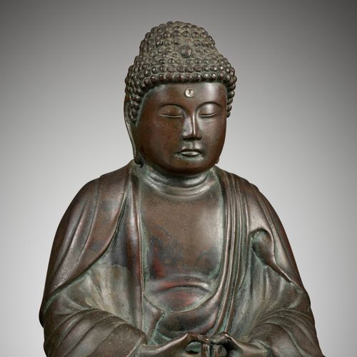 A BRONZE OF AMIDA BUDDHA 阿弥陀佛铜像
日本，19世纪

铸成的阿弥陀佛盘腿而坐，双手在前面打坐，身穿宽大的袈裟，脸部表情安详，眼睛下垂&hellip;