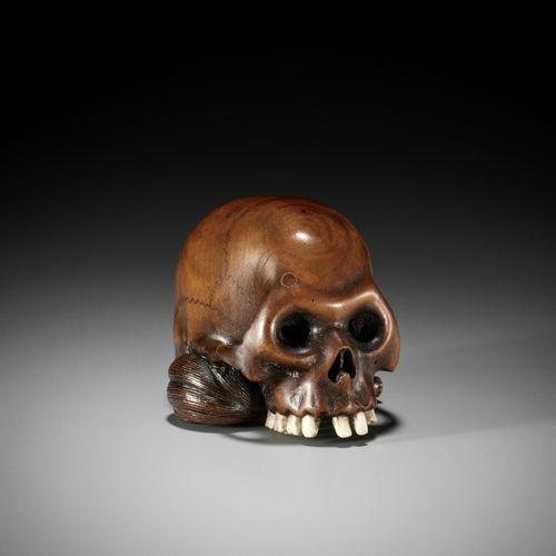 TOMOCHIKA: A LARGE AND NATURALISTIC WOOD NETSUKE OF A SKULL WITH HOSSU TOMOCHIKA&hellip;