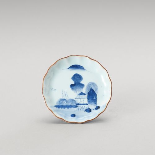 † A SMALL BLUE AND WHITE LOBED PORCELAIN DISH 
日本，明治时期(1868-1912)

这只盘子在展示面用釉下蓝装&hellip;