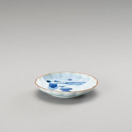 † A SMALL BLUE AND WHITE LOBED PORCELAIN DISH 
日本，明治时期(1868-1912)

这只盘子在展示面用釉下蓝装&hellip;
