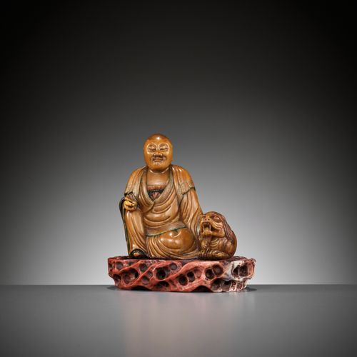 A SOAPSTONE FIGURE OF A LUOHAN WITH A BUDDHIST LION, 18TH CENTURY FIGURA IN SAPO&hellip;