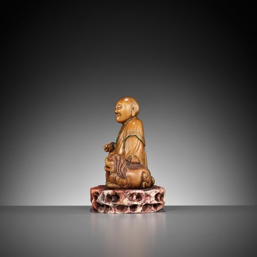 A SOAPSTONE FIGURE OF A LUOHAN WITH A BUDDHIST LION, 18TH CENTURY FIGURE EN PIER&hellip;