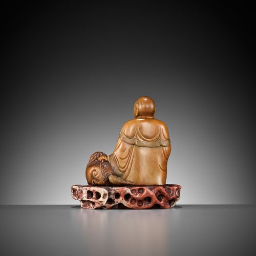 A SOAPSTONE FIGURE OF A LUOHAN WITH A BUDDHIST LION, 18TH CENTURY SEIFSTEINFIGUR&hellip;