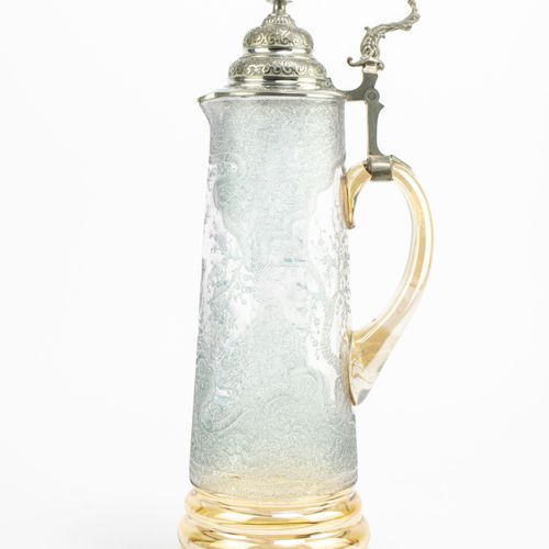 Großer Glaskrug und 6 Gläser 
大玻璃壶和6个玻璃杯
7-pcs., 德国，约1890年，带锡盖的壶，琥珀色五彩玻璃的支架和把手，有&hellip;