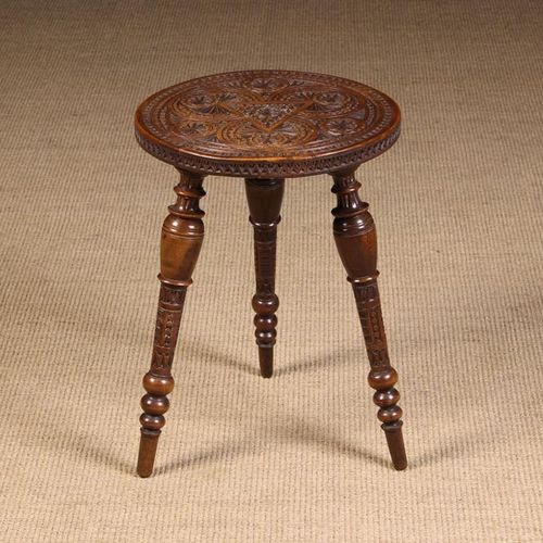 Null 一个19世纪末/20世纪初的三脚凳/桌子，在圆形的顶部复杂地雕刻着几何图案，并在转动的摊开的腿上凸起，高18''（46厘米），直径13''（33厘米）&hellip;