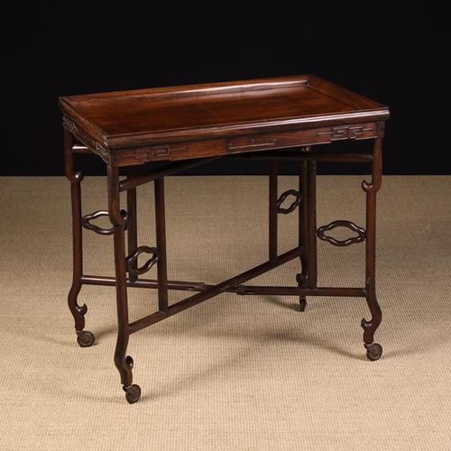 Null 一个19世纪末/20世纪初的中国折叠式托盘顶拉杆桌。长方形的桌面有一个外翻的模具边缘，在一个可旋转的X形框架底座上，有卷轴装饰和拉杆轮，高27½'' &hellip;