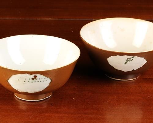 Null 两只19世纪的中国碗，外壁涂有咖啡色釉，有三只画有点缀的小树枝的篮子，很天真。碗站在高脚上，高2¼''（6厘米），直径5''（12.5厘米）。