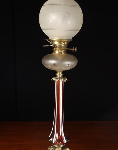 Null Une lampe à huile victorienne. La tige balustre cannelée en verre canneberg&hellip;