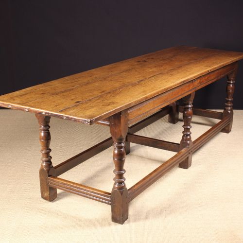 Null 一张查理二世的橡木餐桌，可能是威尔士的，具有良好的颜色和光泽度。三块木板的顶部有裂缝，悬在一个连接的底座上，有六个卷曲的带节的上升的栏杆式的腿，由通道&hellip;