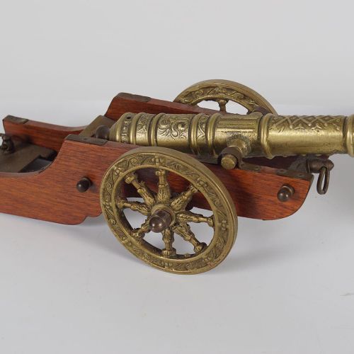 PAIR OF BRASS CANNONS 一对铜制加农炮安装在一个双轮的木制马车上。