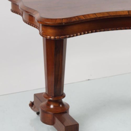 WILLIAM IV ROSEWOOD LIBRARY TABLE 威廉四世的玫瑰木书桌，长方形蛇形的桌面，上面有一个符合要求的楣，在琴键和卷轴的两端，由一个转&hellip;
