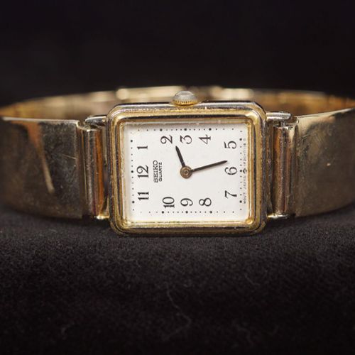SEIKO GOLD PLATED QUARTZ WRISTWATCH SEIKO镀金石英手表，长方形小尺寸表壳，白色表盘和阿拉伯数字。配有9ct.金普通手镯式&hellip;