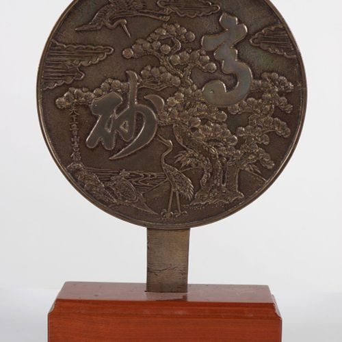 CHINESE QING BRONZE MIRROR 中国清朝的铜镜，一面抛光，另一面装饰着河流风景中的仙鹤，支撑在一个木制的基座上。高37厘米；宽23厘米
