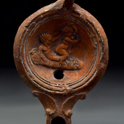 ROMAN TERRACOTTA OIL LAMP WITH EROTIC SCENE 约。公元100-200年。

一盏陶制油灯，盘状的灯身，环形的把手，束腰&hellip;