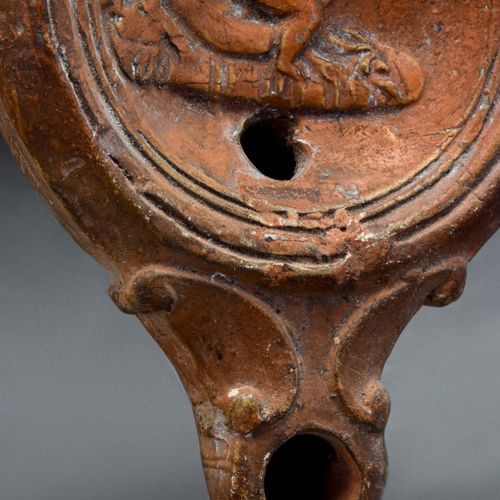 ROMAN TERRACOTTA OIL LAMP WITH EROTIC SCENE 约。公元100-200年。

一盏陶制油灯，盘状的灯身，环形的把手，束腰&hellip;