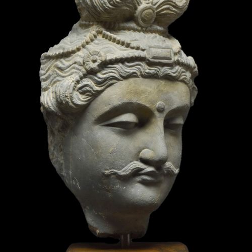 Null GANDHARAN SCHIST的佛教徒头像a。公元100-300年。 
一个片岩石佛头。他被描绘成波浪形的头发，在头带上方打了一个发髻。他的脸部特征&hellip;