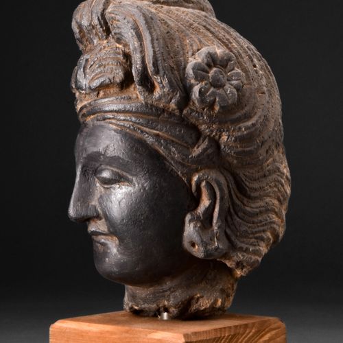 GANDHARAN DARK SCHIST HEAD OF BODHISATTVA 约。公元200-300年。 
这是一个深色片岩雕刻的菩萨头像，脸颊柔和圆润，&hellip;