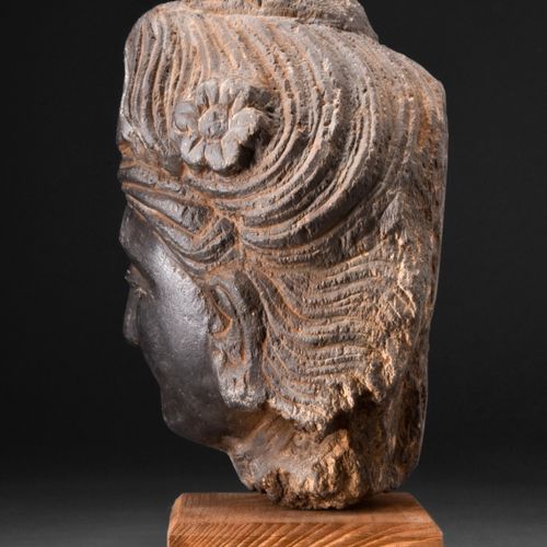 GANDHARAN DARK SCHIST HEAD OF BODHISATTVA 约。公元200-300年。 
这是一个深色片岩雕刻的菩萨头像，脸颊柔和圆润，&hellip;