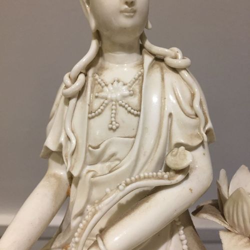 Null 中国瓷器白瓷观音像，清末，模印长袍和珠链，坐在岩石基座上，下面的水里长出了莲花，她的左边是一朵大莲花，左臂上放着如意宝杖，高28.5厘米



 品相&hellip;