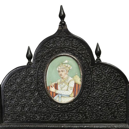 Null 一件精雕细琢的黑檀木四折屏风和临时桌子，北印度，19世纪下半叶，屏风的四块面板上大量雕刻着滚动的花卉图案，每块面板上都有16幅微型肖像，镶嵌在金属支架&hellip;