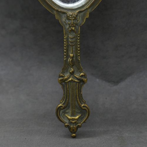 Null Miroir à main à décor de feuillage en bronze. Hauteur: 25 cm