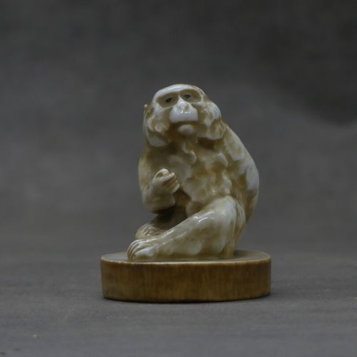 Null Singe en céramique imitant l'ivoire. Hauteur : 6.5 cm.