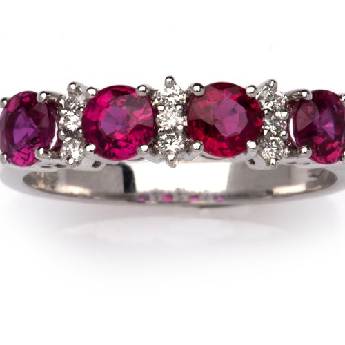 An 18k white gold ruby and diamond ring 一枚18K白金红宝石和钻石戒指，正面镶有四颗圆形切割的红宝石，中间镶有明亮式切割&hellip;
