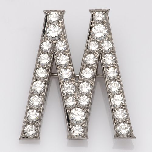 A 14k white gold diamond brooch 一枚14K白金钻石胸针，设计为字母 "M"，通体镶嵌着明亮式切割钻石。 毛重7克。