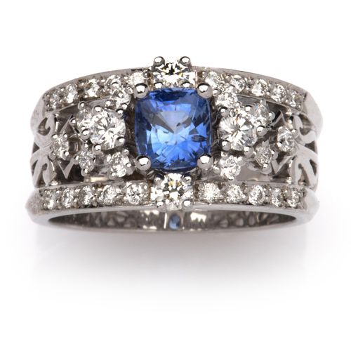 An 18k white gold sapphire and diamond ring 一枚18K白金蓝宝石和钻石戒指，由两条镶有明亮式切割钻石的带子组成，中心&hellip;