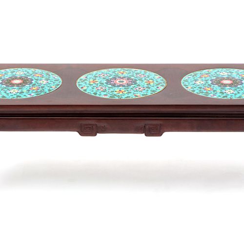 A Chinese carved hardwood and cloisonné low table 一张中国硬木雕刻和景泰蓝矮桌，20世纪，长方形的模具顶部有三&hellip;