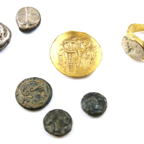 Een collectie oude munten en een ring Una colección de monedas antiguas y un ani&hellip;