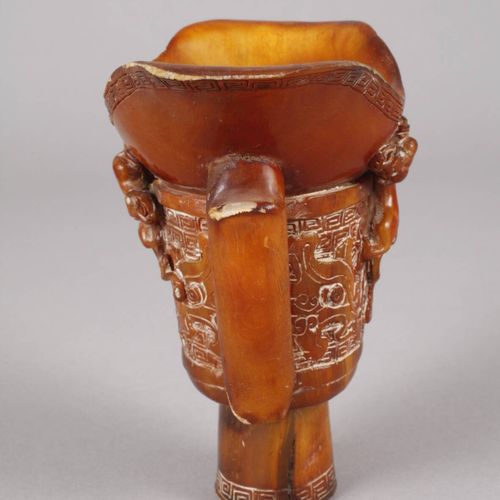 Null 
Horncup
China, c. 1900, unsigned, an elaborately carved footed cup of ambe&hellip;