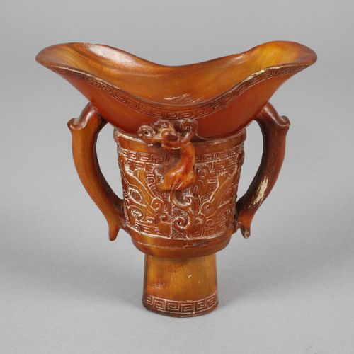 Null 
Horncup
China, c. 1900, unsigned, an elaborately carved footed cup of ambe&hellip;