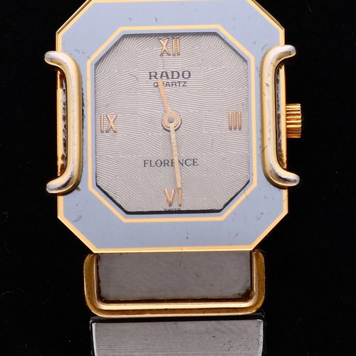 Null RADO瑞士雷达表，型号为Florence，长方形轮廓的表壳，带有金色元素。配有金色链节的精钢表带和折叠式表扣。石英表。宽度为21毫米。