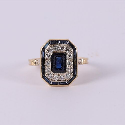 Null An octagonal 18 carat gold ring with 14 diamonds and blue sapphires.
