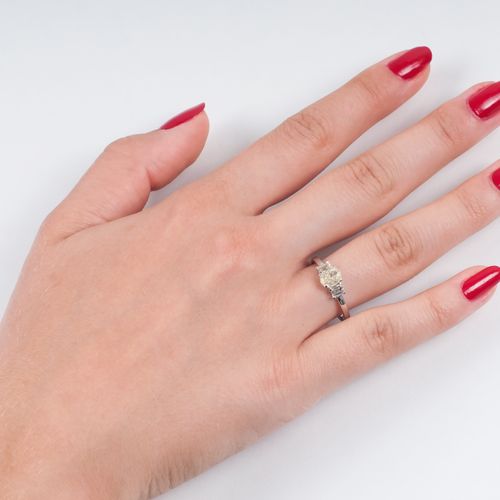 A Fancy Diamond Ring. 18K白金，有标记，经罗丹处理。椭圆形切割的花式钻石约0.87克拉。与两个小的花式钻石（祖母绿切割）共约0.40克拉&hellip;