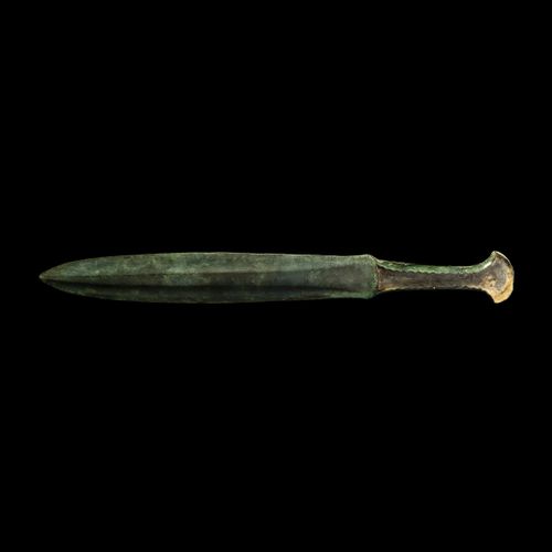 Null 卢里斯坦带锯齿手柄的匕首。公元前12-9世纪中期。一把青铜匕首，剑身渐渐变圆，中间有凸起的面板，剑柄两边有浅浅的插口，用来装木头或骨质的鳞片，边缘有锯&hellip;