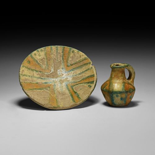 Null 西方亚洲的琉璃壶和碟子。公元前8-7世纪。一套陶器包括一个小壶，直颈，颈部与肩部相接处有一个脊，穿过一个把手，椭圆形的斜方体；一个碟子，有低矮的凸起底&hellip;