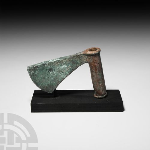 Null Luristan Sar'e Tabar斧头。公元前三千年，一个大型的青铜斧头，弯曲的切割刀片向下翻转，渐渐变成一个圆柱形的轴；附带一个定制的展示架。&hellip;