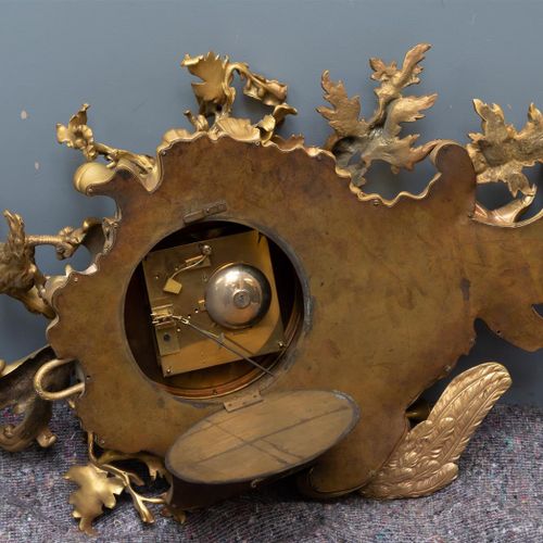 Null 一块大写的路易十五风格的卡特尔计时器，装在一个镀金的青铜盒子里，法国大约在1880年，上面有一位女士吹着小号和一只老鹰在花卉图案和玫瑰花丛中的装饰，珐&hellip;