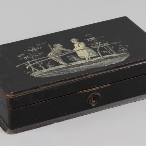 Null 一个游戏盒，黑色漆面，白色画有一个猎人和桥上的女人，里面有4盒骨瓷片。(B)

h.6 x w. 27 x d. 15 cm