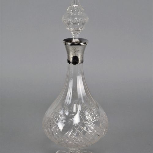 Carafe around 1930 1930年左右的玻璃杯

由透明水晶玻璃制成，有丰富的切割装饰。碟形支架上有星形切割，强烈的球形杯身。顶部的顶饰有银质底座&hellip;